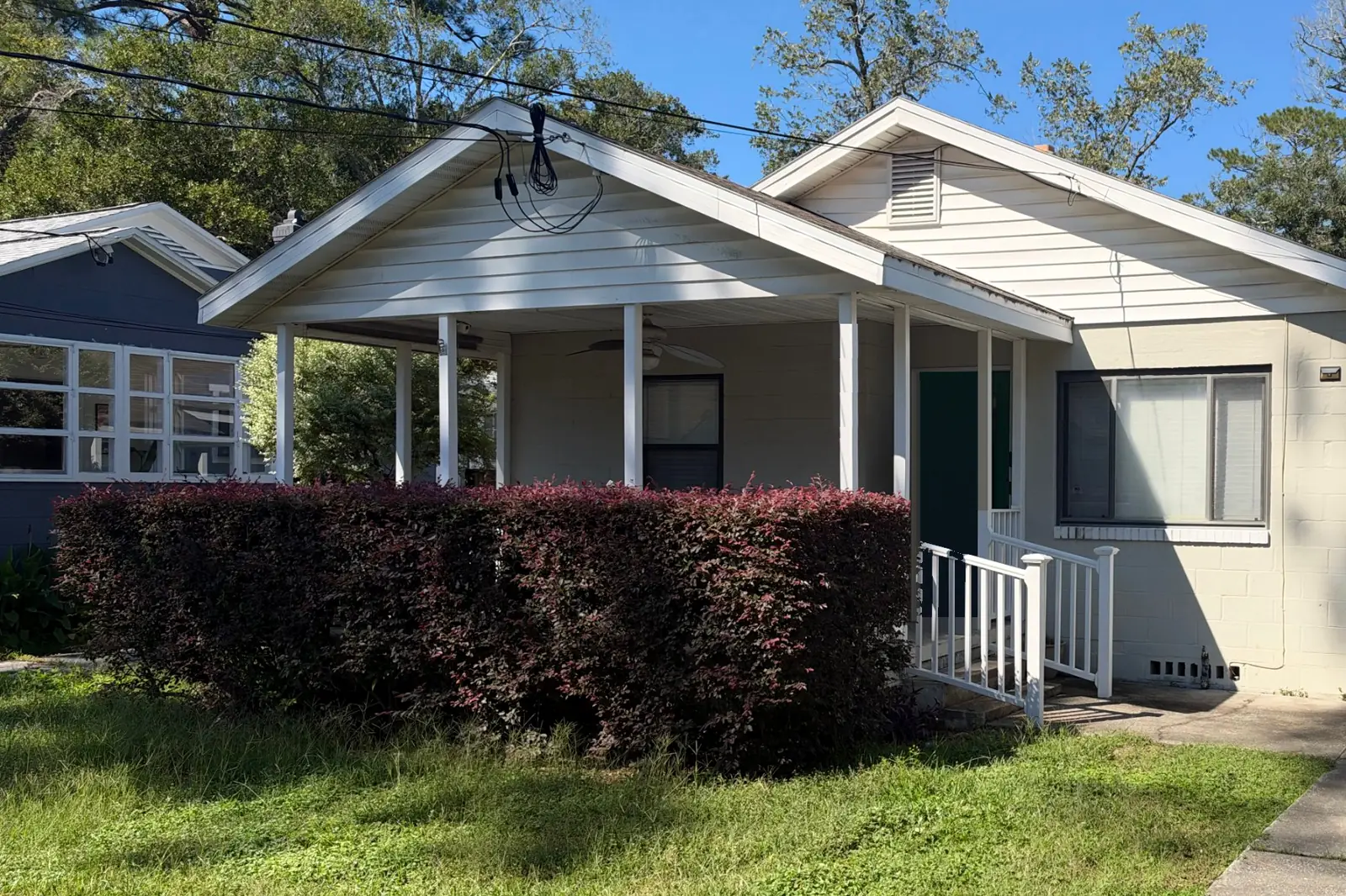 Single-story bungalow with a covered front porch and white railing in Northeast Florida